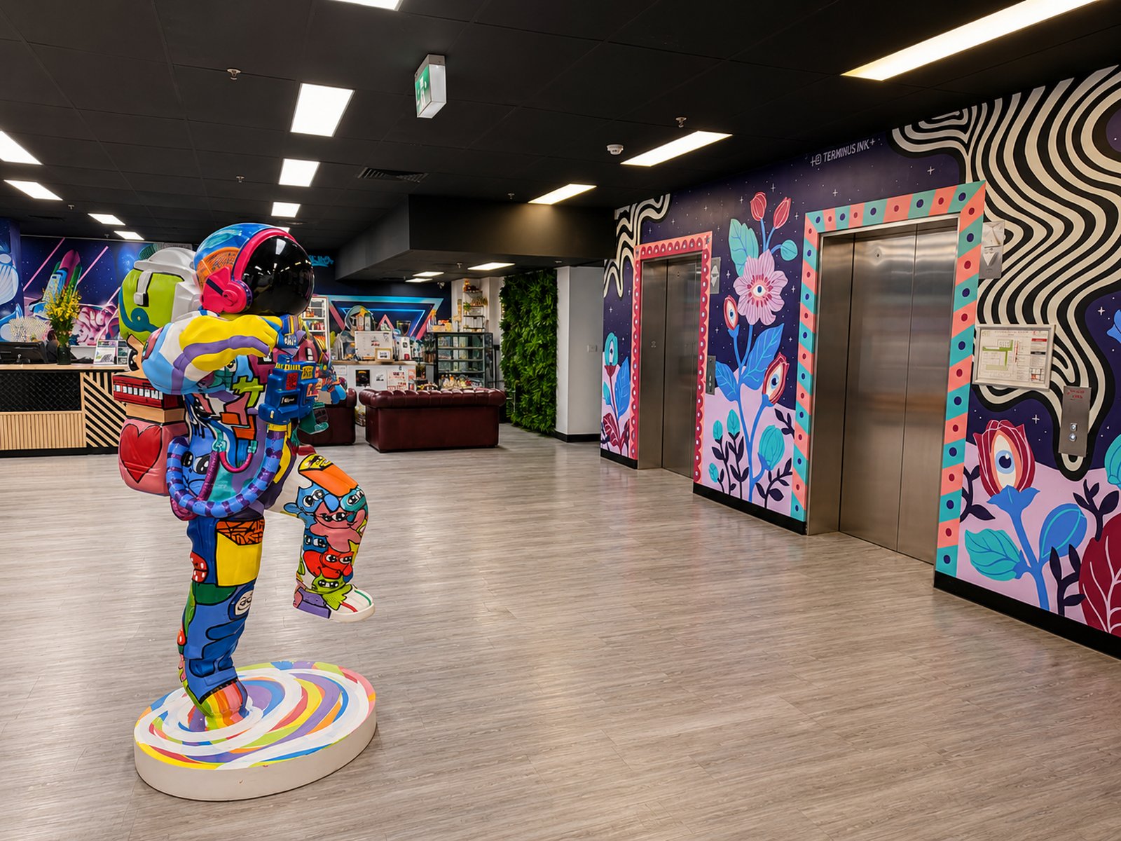 Colourful entrance lobby with elevators, mural art and an astronaut sculpture