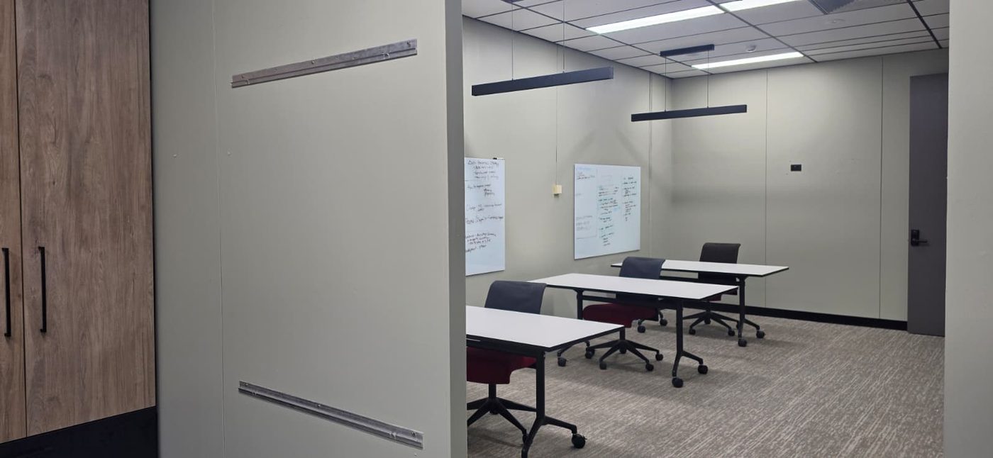 Southbank training room viewed through the doorway, with whiteboards and moveable tables